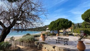 A coastal park with benches, a stone wall, and a view of the sea. - Vacances à la mer apartments climatisés avec terrasse privative (Le Lavandou)