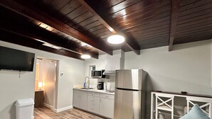 Une cuisine compacte équipée d’un four à micro-ondes, d’un réfrigérateur et dotée d’un plancher en bois.