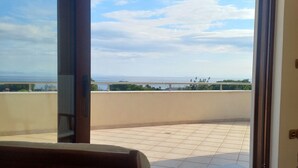 A balcony with a view of the sea, a table, and a chair. - Salty Sea Breeze nearby Athens airport (Artemis)