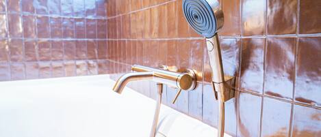 Une salle de bain avec une baignoire, une douche et des murs carrelés.