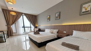 A hotel room with two beds, a small table, and a chair.