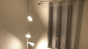 Una habitación con dos camas, una mesita de noche, una lámpara y una ventana con cortinas.