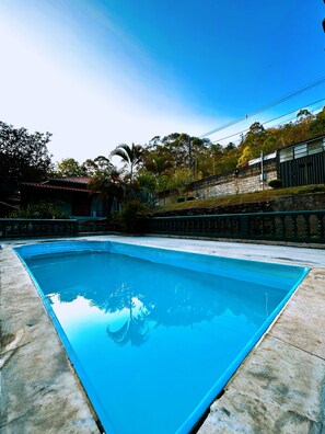 Swimmers can enjoy a refreshing dip in this pool surrounded by lush trees.