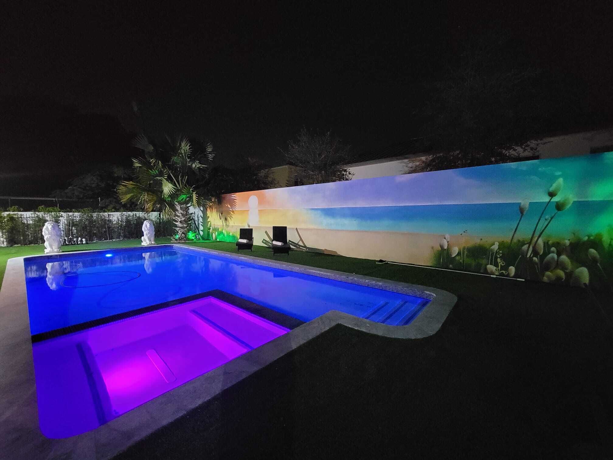 A swimming pool with a mural and decorative lighting.
