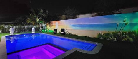 A swimming pool with a mural and decorative lighting.