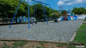 A playground with swings and a climbing structure. - Luxe Escape Residential Housing (Portmore)