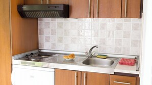 A compact kitchen with a stove, sink, and wooden cabinets. - Single studio with Kitchen, 3 minutes (by foot) to the Beach & Hiking paths. (Diafani)