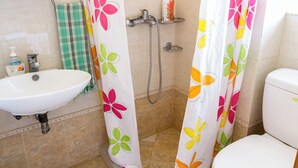 A bathroom with a white sink, shower, and toilet. - Single studio with Kitchen, 3 minutes (by foot) to the Beach & Hiking paths. (Diafani)
