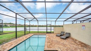 Una piscina coperta con due sdraio e vista su un lago.