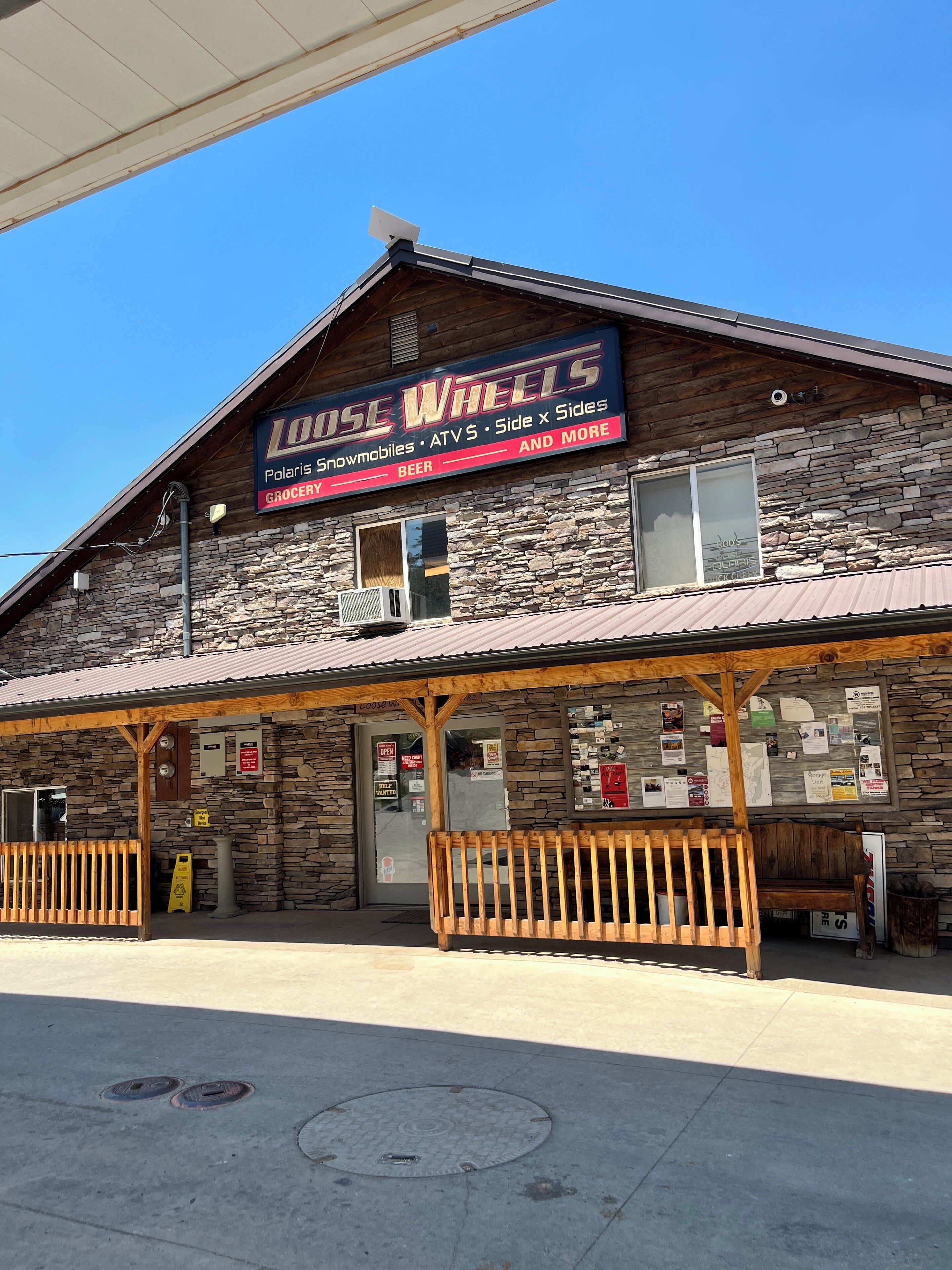 A building with a sign reading "Loose Wheels" offering a grocery, beer, and more.