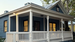 A two-story house with a covered porch and a dark blue exterior.