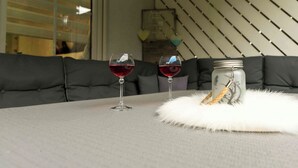A dining area with a table, two wine glasses, and a jar with a rope. - Lake Constance pearl! Cozy 3.5 room apartment with beautiful garden near Lake Constance (Friedrichshafen)