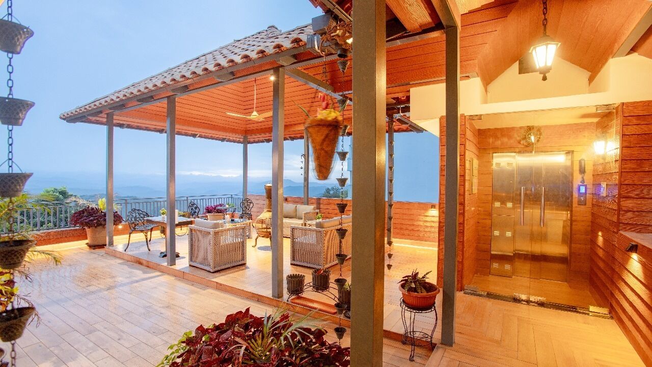 Um alpendre coberto com assentos, sauna e vista para a paisagem.