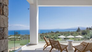A balcony with wicker chairs and umbrellas overlooking a scenic landscape with mountains and a body of water. - Agapanthus Ultimate Luxury Villa (Likotinarea)