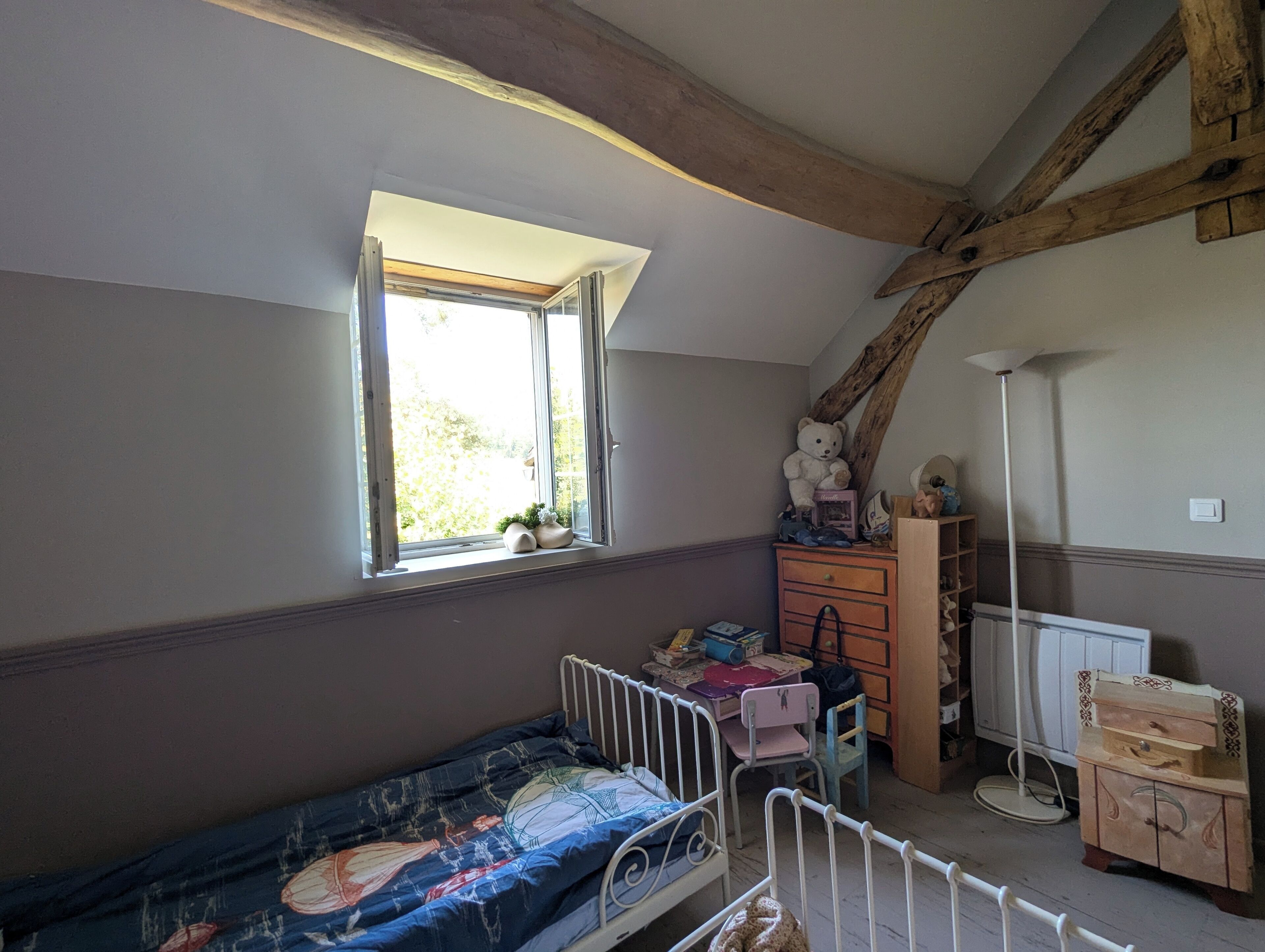 A child's bedroom with a bunk bed, a dresser, a desk, and a window.