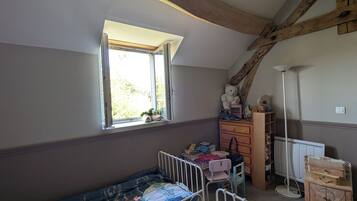 A child's bedroom with a bunk bed, a dresser, a desk, and a window.