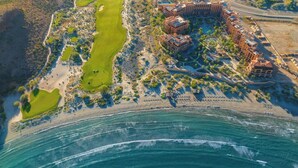 An aerial view of a coastal resort with a golf course, beachfront, and a large hotel complex. - Luxury Escape with Ocean Views in Loreto (Loreto)