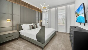 Une chambre moderne avec un grand lit, une télévision et une commode.