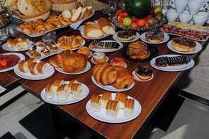 Une table garnie de diverses pâtisseries et de produits de boulangerie.