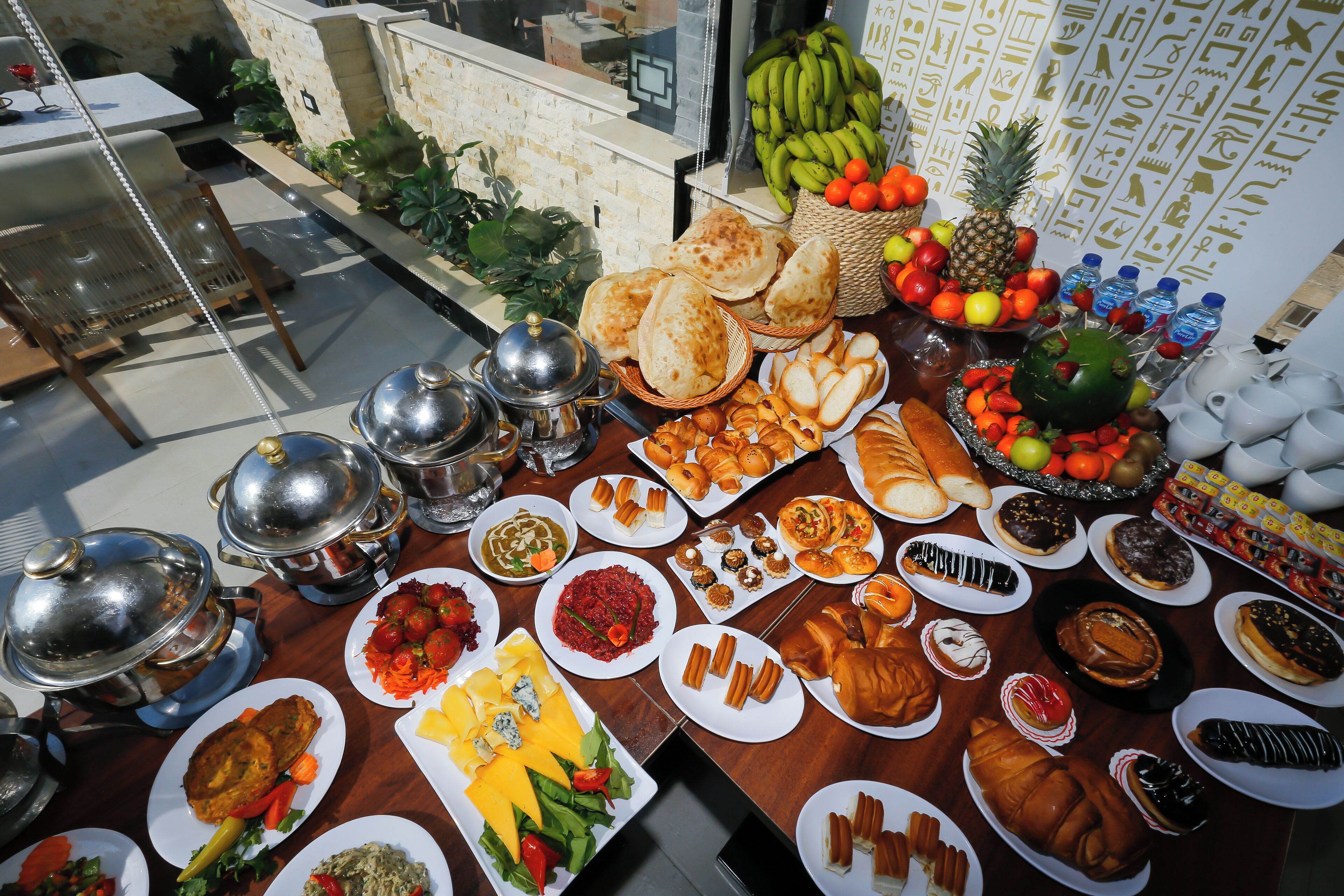 A buffet table with various food items and a grill area.