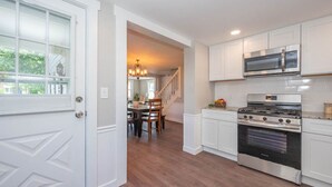 A kitchen with white cabinetry, a stainless steel range, and an oven. - Beautiful 3 Bedroom Downtown Salem Home (Salem)