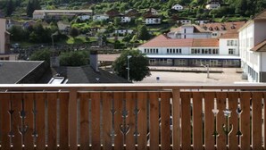 Un balcón con vistas a una colina con casas.