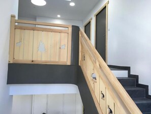 Eine Treppe mit hölzernen Geländern und einer Holzvertäfelung mit Baum- und Tiermotiv.