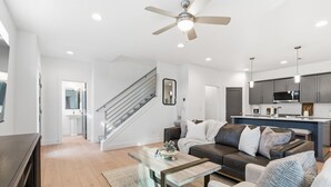 Ein modernes Wohnzimmer mit Sofa, Couchtisch und einer Treppe, die in einen anderen Raum führt.