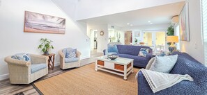 Un salon moderne avec des meubles en osier, un canapé bleu et une table basse.