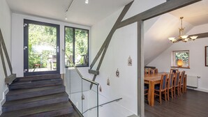 A staircase with glass railings leading to a dining area with a wooden table and chairs. - Luxurious sandstone villa - 320 sqm - 7 rooms (Dresden)