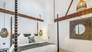 A bedroom with a four-poster bed, a bedside table, a mirror, and a hanging light fixture. - The B Hive at Buckstone House (Carnforth)