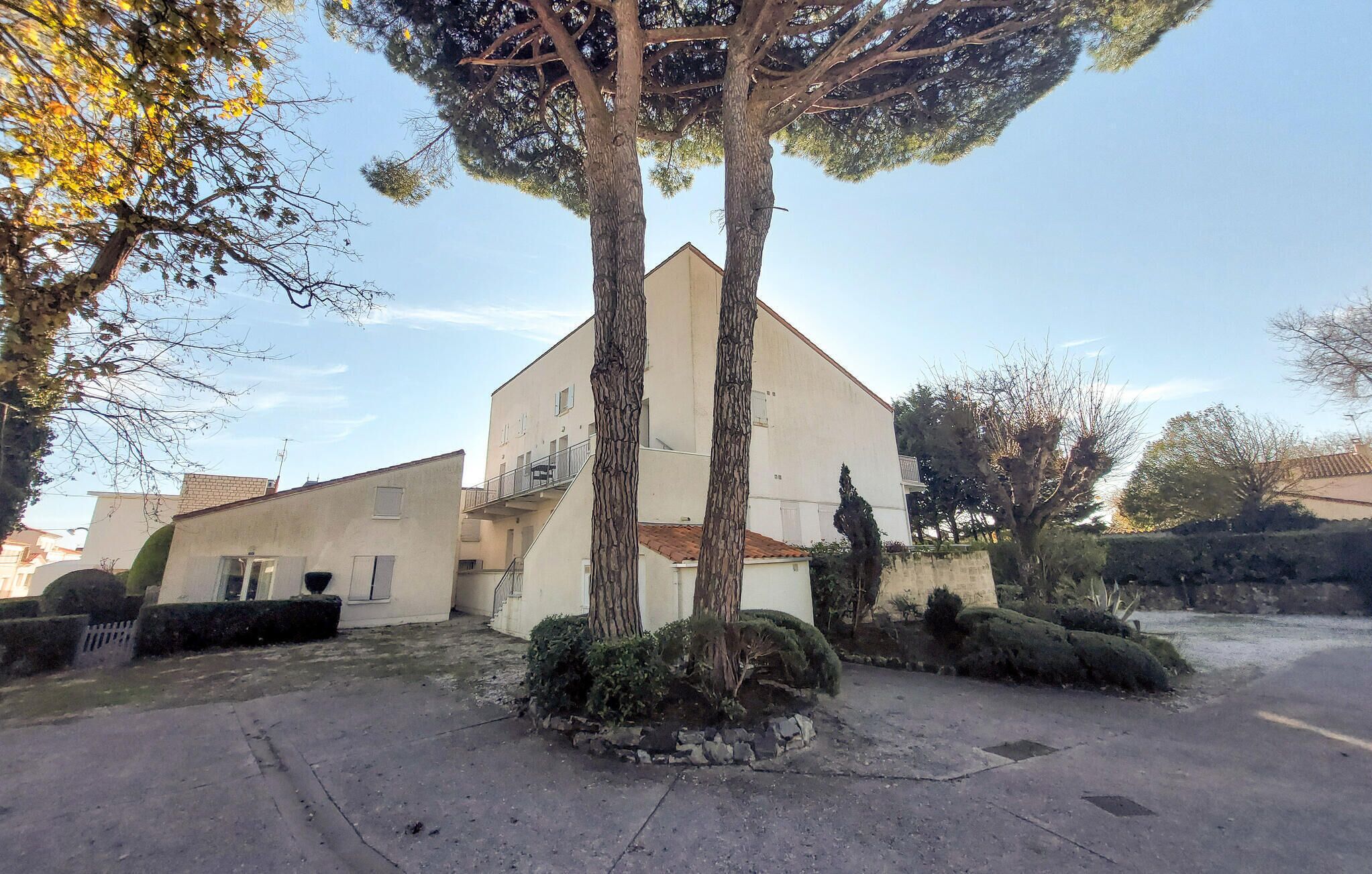 Un edificio de dos pisos con techo plano y un pequeño porche delantero.