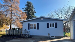 A small, single-story house with a porch and a garage. - Private Lakeside Escape on Devils Lake  (Devils Lake)