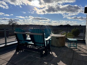 Une terrasse avec des chaises et une table, offrant une vue sur le paysage urbain.