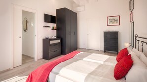 A bedroom with a bed, a wardrobe, a dresser, and a mirror. - White Apartment with Terrace and Lake View (Costermano)