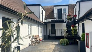 Ein Innenhof mit Treppe, Bank und Kübelpflanzen.