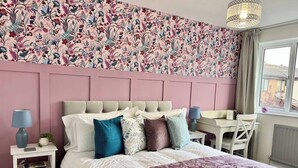 A bedroom with a bed, bedside tables, a desk, and a chair. - 3BR | Contractors | Parking, Garden (Saffron Walden)