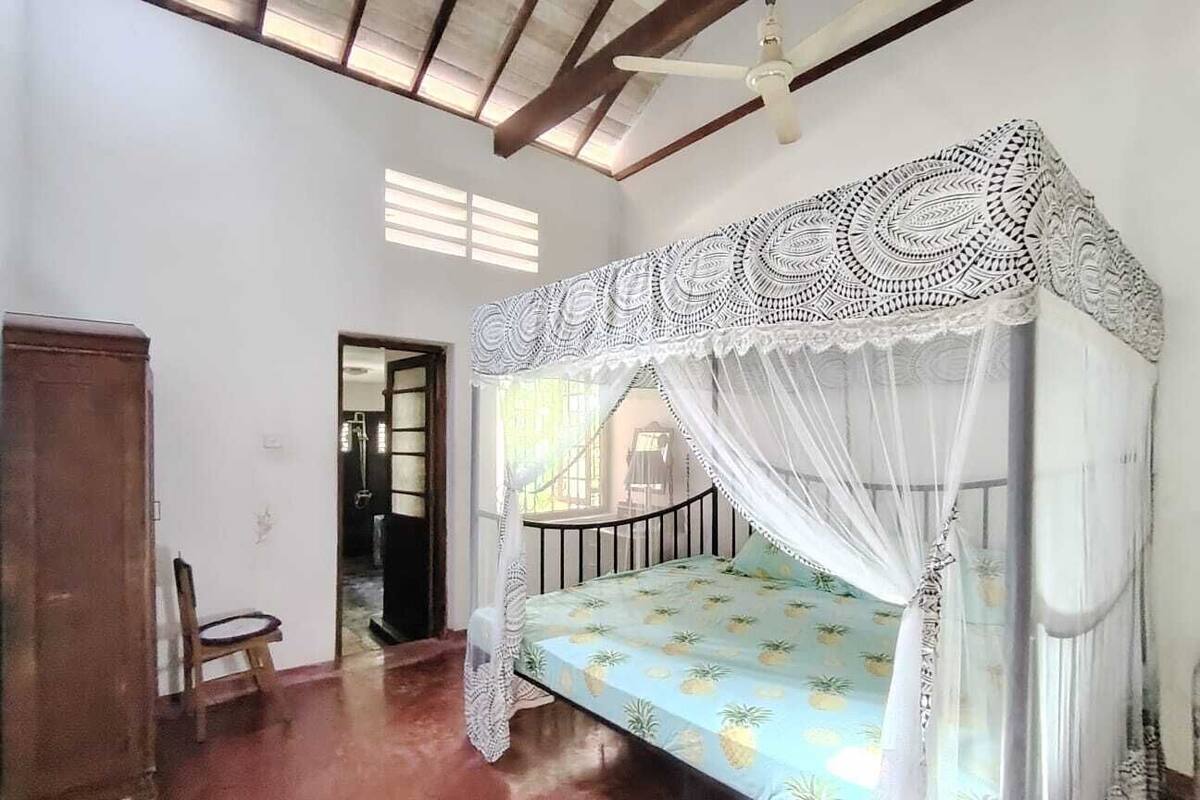 A room with a bed, a chair, and a wardrobe.