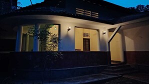 A modern house with a large glass window, a door, and a staircase leading to the upper floor. - Thuru Sewana Villa (Unawatuna)