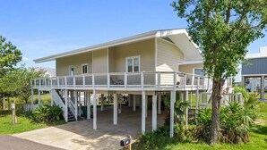 A two-story house with a covered porch and a staircase leading to the upper level. - Sea Level BSL 3BR 3BA Waterfront (Shoreline Park)