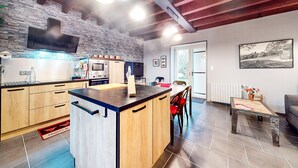 Una cocina moderna con una isla central, armarios de madera y salpicadero de piedra.