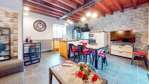 Una cocina moderna con un salpicadero de pared de piedra, vigas de madera y un reloj grande.