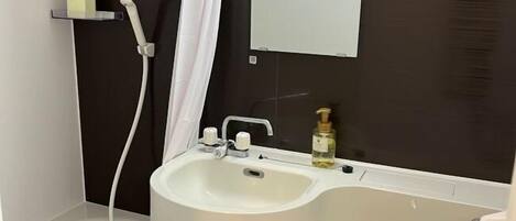 A bathroom with a bathtub, a sink, a toilet, and a mirror.
