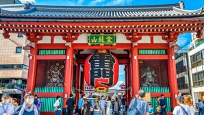 Un portón japonés tradicional con un arco grande rojo y una estructura central con forma de rostro.