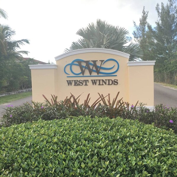A sign for West Winds with a logo and name. - Cozy 2-bedroom townhome in lovely gated community in Nassau with WiFi and AC. (Nassau)