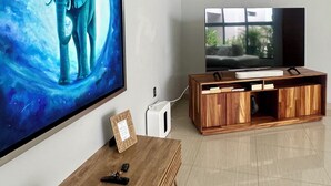 A modern living room with a large flat-screen TV, wooden entertainment unit, and a wall-mounted picture of an elephant. - Casa Mosso  (Oaxaca)