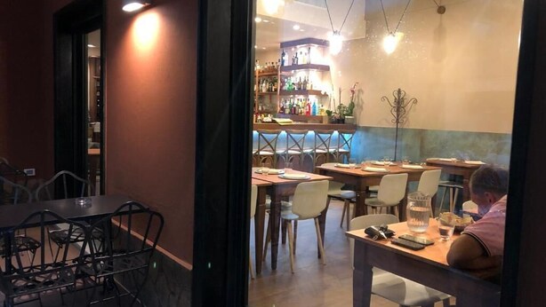 A restaurant with a bar area, tables, and chairs. - Tuibeds (Arenzano)