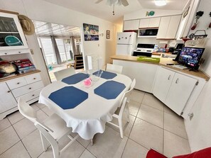 Cozy living space with a dining area and kitchenette, featuring a dining table, chairs, and a small island.