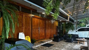 A spacious outdoor area with wooden cabinets, seating, and potted plants.