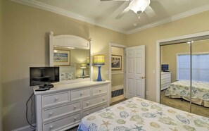 A bedroom with a bed, dresser, television, and a door leading to another room. - Charming 3-bedroom Golf Villa in Murrells Inlet South Carolina (Murrells Inlet)